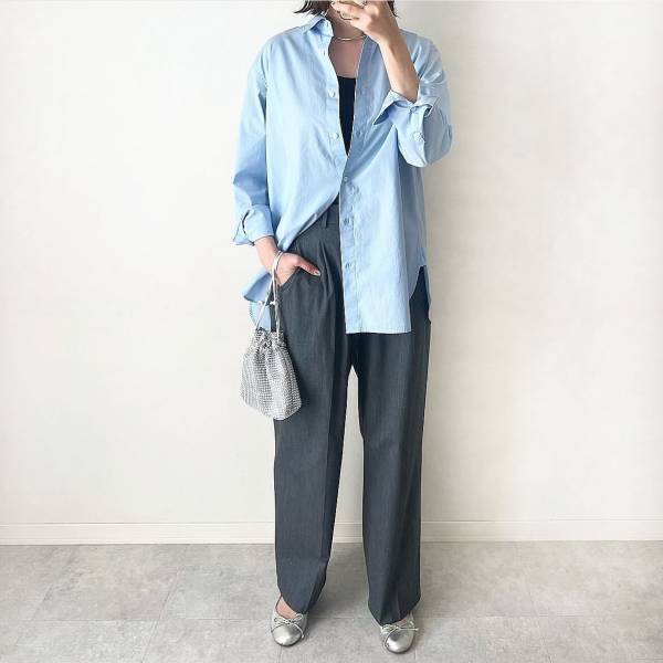 Light-blue oversized shirt partially tucked into charcoal wide trousers