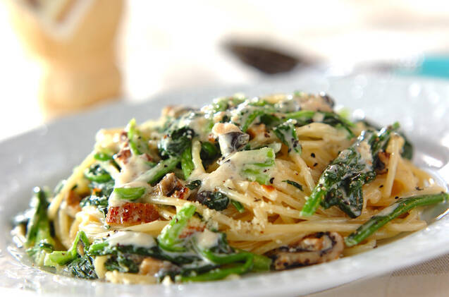 白い皿に盛りつけられた穴子とほうれん草入りのクリームパスタ