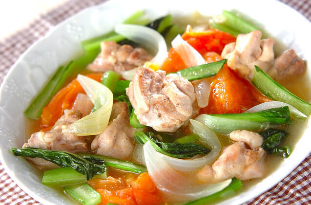 白い皿に盛り付けられている鶏肉と野菜のビール煮