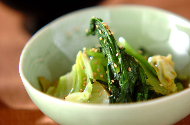 黄緑色の皿に盛られた小松菜の炒め物