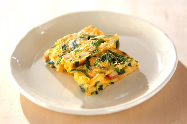 白い皿に入ったニラとカニカマの卵焼き