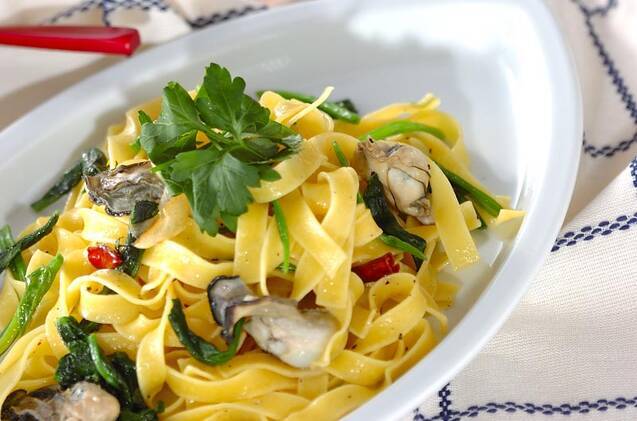 オーバル皿にカキとほうれん草のパスタが入っている