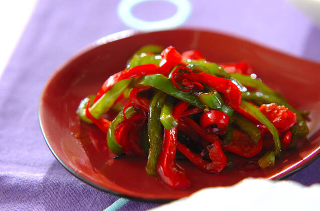 赤色の皿に盛られた、2色ピーマンのきんぴら
