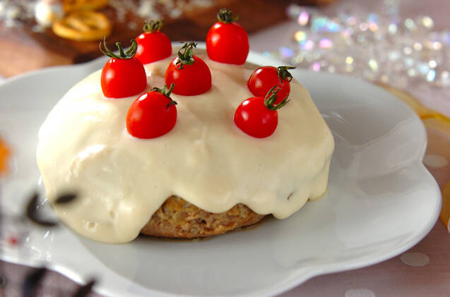 白い花形の皿に盛られたチーズソースハンバーグ