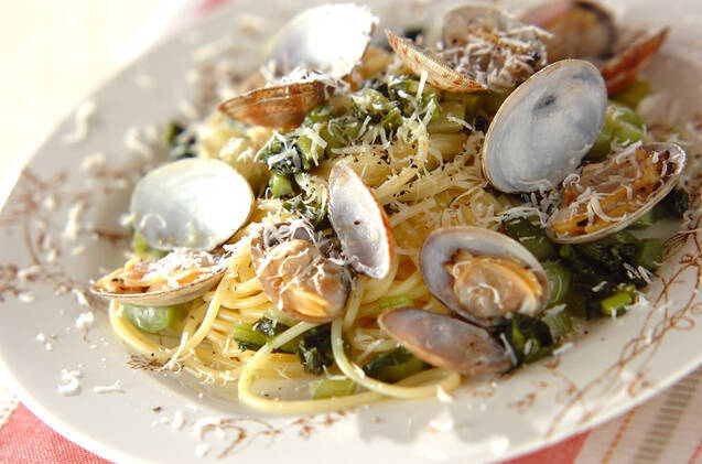 白い皿に盛りつけられたあさりと野沢菜漬け入りのスパゲッティ