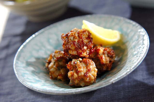 レモンが添えられたれんこんとイワシの団子