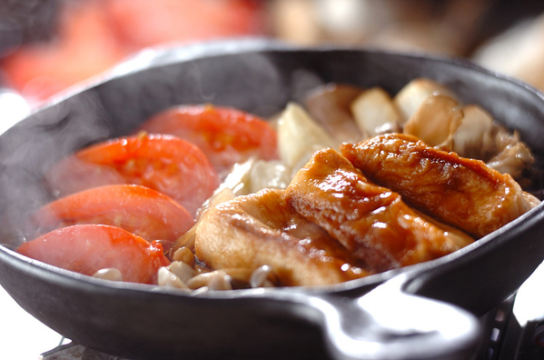 スキレットで煮込まれている麩ときのこ、トマトのすき焼き