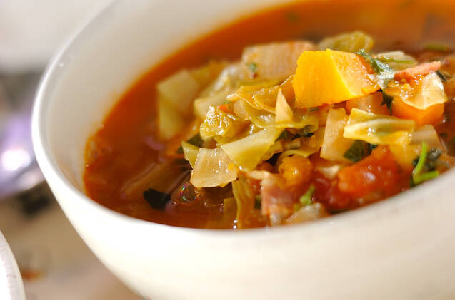 白いボウルに盛りつけられたベーコンとたっぷり野菜のミネストローネ