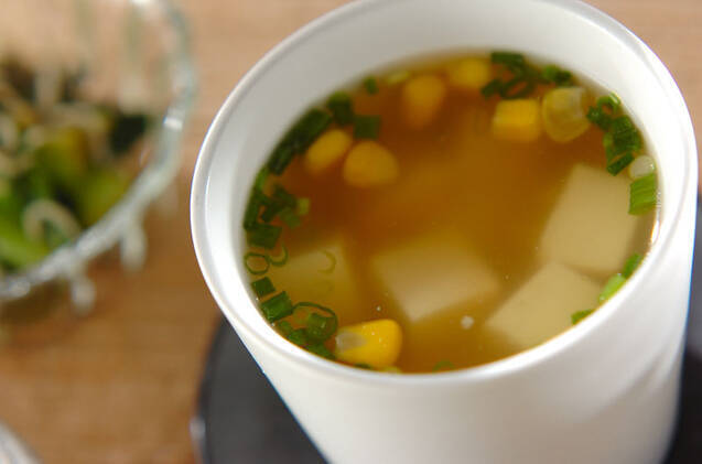 白いスープカップによそったコーンと豆腐のスープ