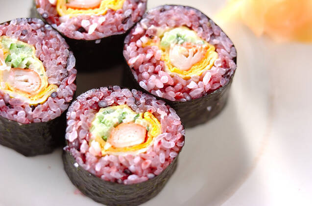 白い皿に盛り付けた4切れの黒米巻き寿司