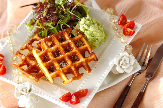 白くて四角いお皿にサラダと食べる米粉ワッフルが置いてあり、端にミニトマトが添えられている