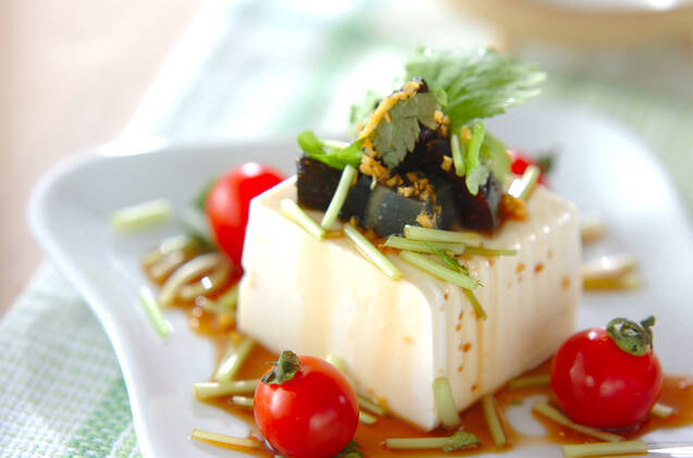 白い皿に盛りつけられたピータン豆腐とミニトマト