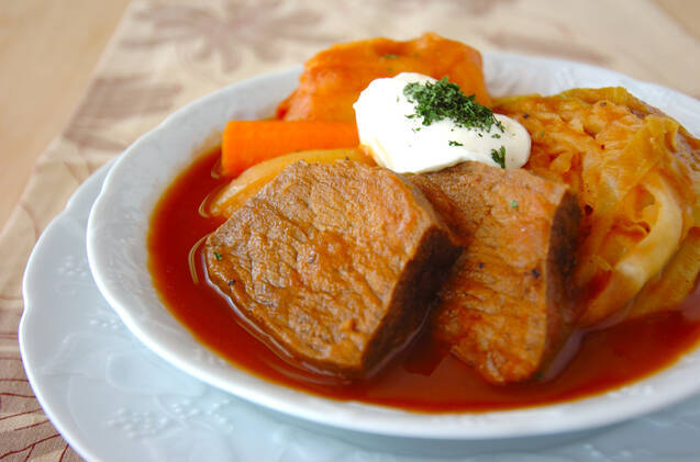 白い皿に盛り付けられた牛もも肉とビーツのボルシチ