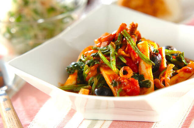 白の四角い皿に盛られたイカと野菜のトマト煮込み