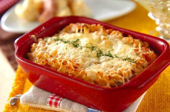 赤いグラタン皿にトマトの焼きリゾットが盛られている