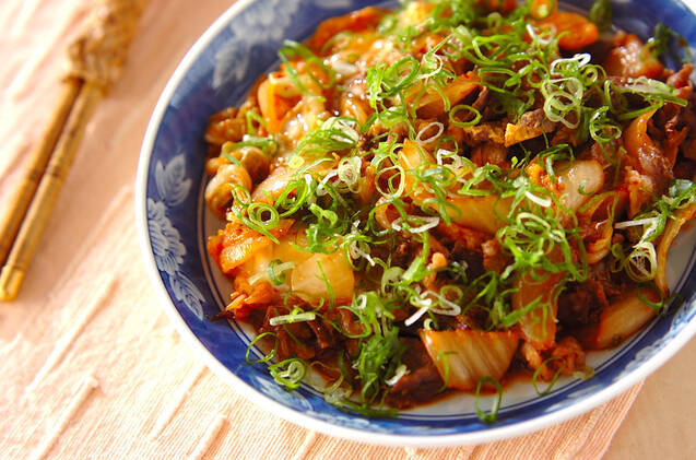 青い模様入りの皿に盛りつけられた牛肉と玉ねぎ、キムチの卵とじ