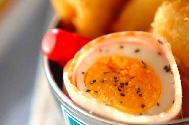 銀色の器の中のゆで卵のベーコン巻き