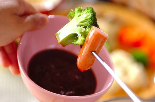 ピンク色の器に入ったチリソース入りカクテルソースと、鉄串に刺さったブロッコリーとウインナー