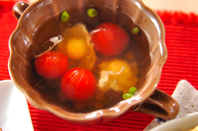 茶色いカップに入ったうずらの卵とトマトのコンソメスープ
