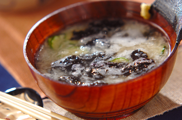 木のお椀に盛りつけられたきゅうりと焼き海苔入りのとろろ汁