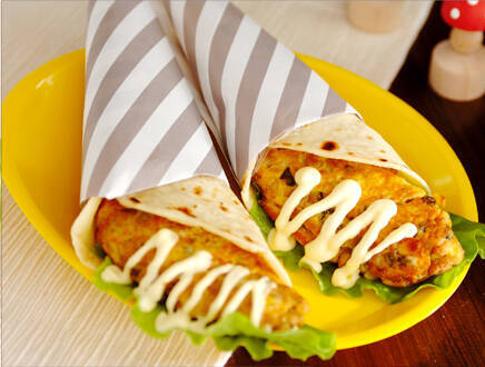 お皿に盛られたトルティーヤに巻かれたオムレツ2つ