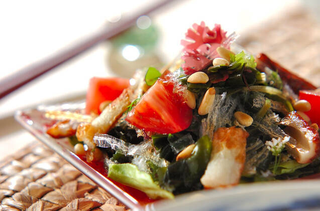 角皿に盛りつけられたちくわや海藻などのエスニック風味サラダの奥に、箸置きに置かれた箸が添えられている