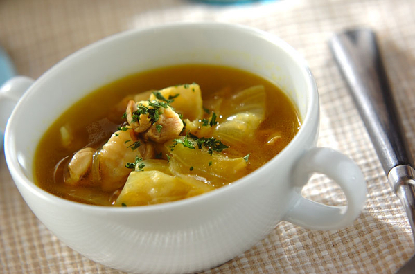 白いスープカップに盛り付けられた、鶏もも肉のカレースープ