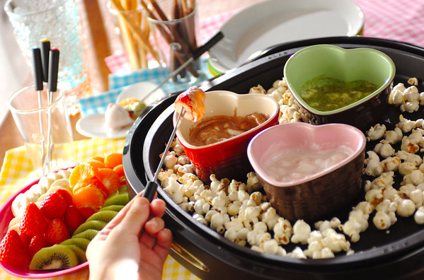 ホットプレートからフォンデュしたいちごを取っているところ