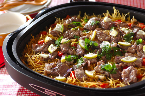 黒い四角のホットプレートに入ったステーキパスタパエリア