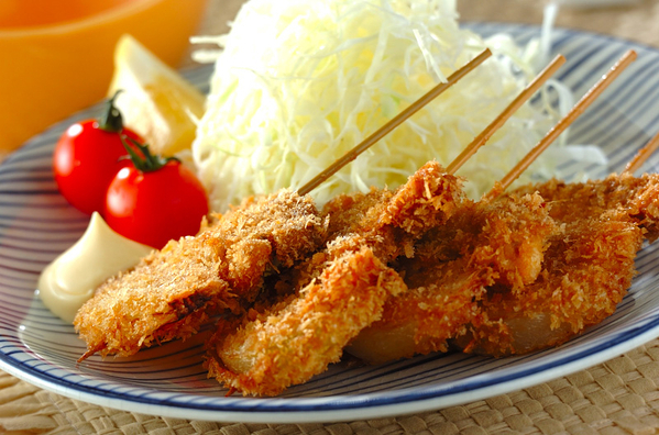 青いボーダー柄のプレートに盛り付けられた豚ヒレ肉の串カツ