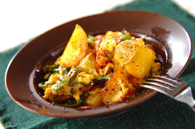 茶色い皿に盛り付けたポテトとソーセージの卵とじ