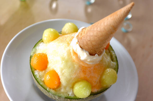 メロンの皮で作った器にメロンのかき氷やアイスクリームがトッピングされている様子