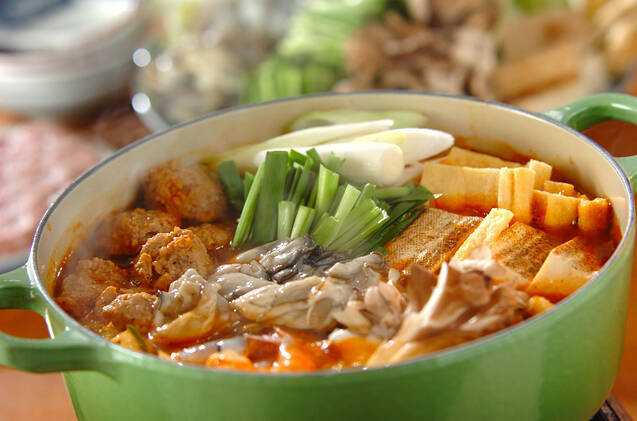 緑色の鍋に入った豚ニラキムチ鍋