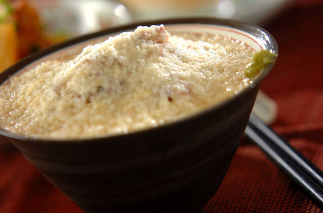 濃色の丼鉢に盛りつけられたわさび添えの十六穀入りとろろごはん