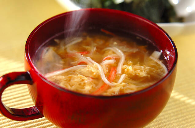 赤いカップに盛りつけられた玉ねぎとカニかまのふんわり卵スープ