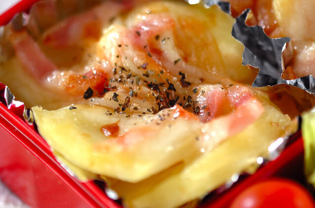 赤い容器に入れたポテトのチーズ焼き