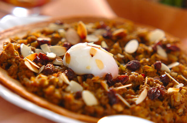 白いお皿に盛られた温泉卵のせドライカレーピザ