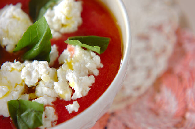 白いカップに盛りつけられたチーズトッピングの完熟トマトスープ