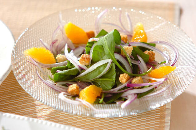 ガラスのお皿に盛られたサラダほうれん草とオレンジのサラダ
