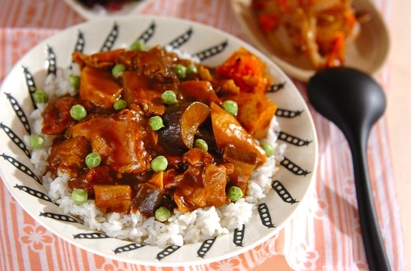 黒い模様の入った皿に盛り付けられている長ねぎ入り厚揚げカレー