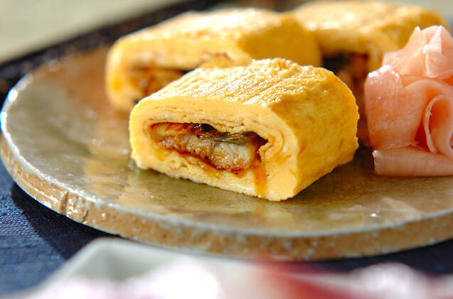 土肌の皿に盛りつけられたう巻き卵焼きと添え物の甘酢しょうが