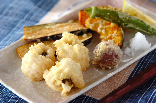 白い皿に野菜の天ぷらや大根おろしと一緒に盛られた、鱧の天ぷら
