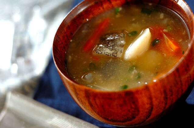 木のお椀に入っている塩たらと大根、にんじんのみそ汁