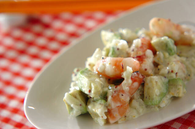 白い楕円型の皿に盛り付けられている海老とアボカドのマヨサラダ