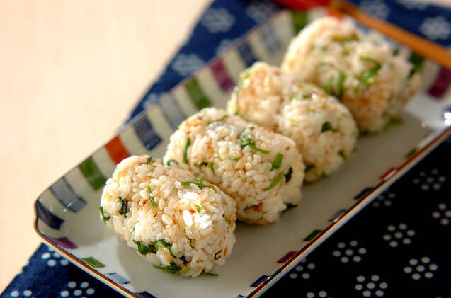 角皿に盛りつけられたせりとかつお節入りのしょうゆ味おにぎり