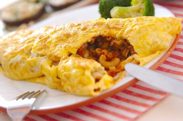 白い丸皿に盛り付けられたミートソース入りオムレツとブロッコリー