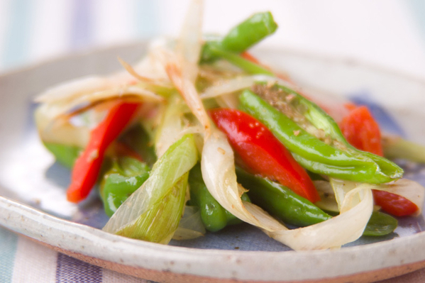 グレーの和食器に盛られた、ししとうのカラフル炒め