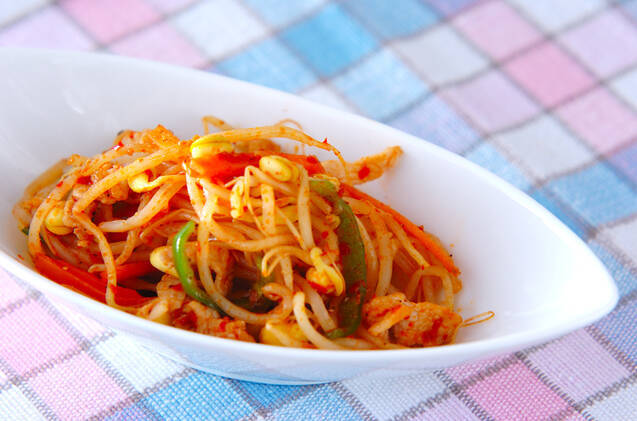 細切りにんじんとピーマンを入れたピリ辛もやしを盛った白い器