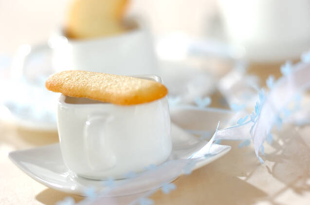 白いコーヒーカップにのせたラング・ド・シャ