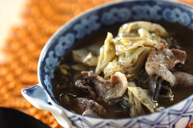 青い柄の器に盛り付けた豚バラ肉のピリ辛黒ごまスープ